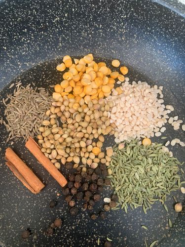 Step 3.1: In a dry pan, roast the chana dal, urad dal, coriander seeds, fennel seeds, cumin seeds, peppercorns, and cinnamon stick over medium heat until fragrant