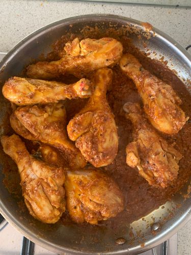 Step 6.1: Add the seared chicken drumsticks to the pan and mix well so they’re coated in the masala
